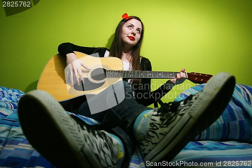 Image of Brunette playing guitar