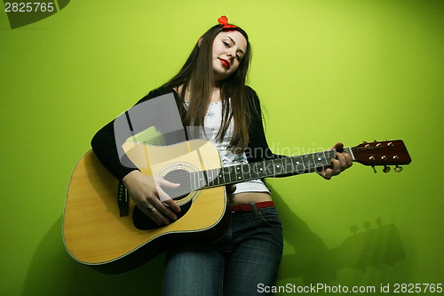 Image of Woman  enjoys playing guitar