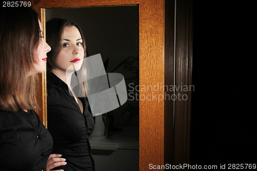 Image of Young brunette posing in front of mirror