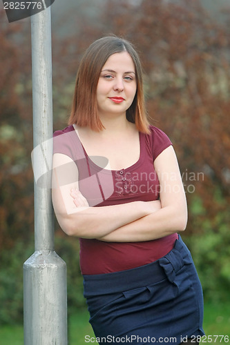 Image of Woman leaning against street pole