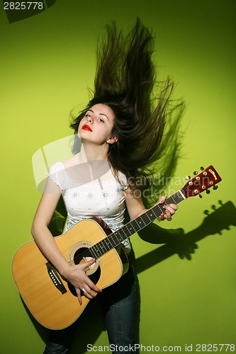 Image of Young brunette playing guitar