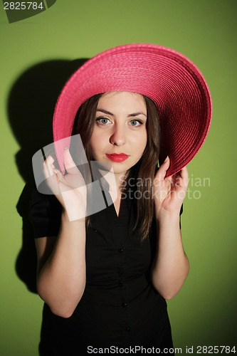 Image of Girl with pink hat on green background