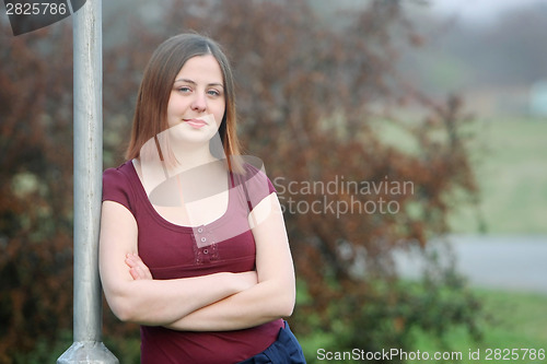 Image of Girl leaning against street pole