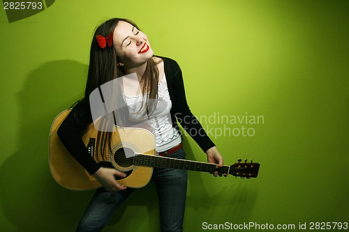 Image of Brunette enjoys playing guitar