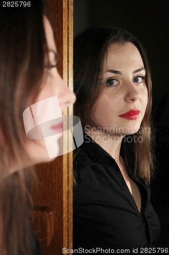 Image of Woman posing in front of mirror