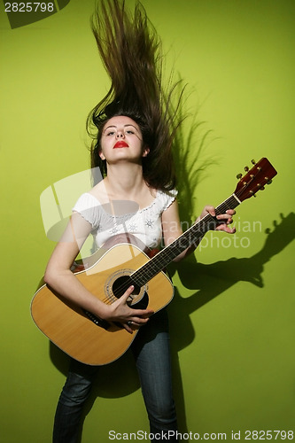 Image of Young woman playing guitar