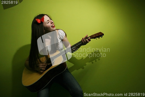 Image of Brunette wildly playing guitar