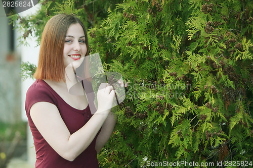 Image of Brunette posing with trees