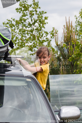 Image of Little girl and car with surfboard