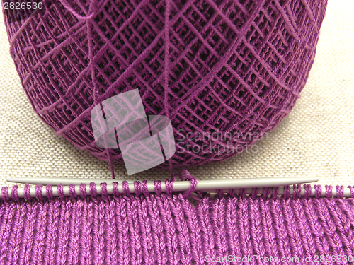 Image of Pink colored knitting on a  beige background