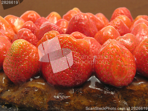 Image of Lateral close-up view of a strawberry cake on brown background