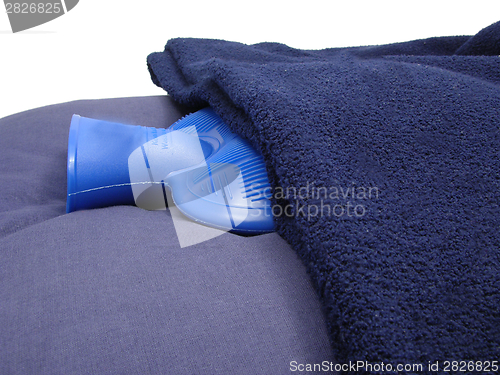 Image of Blue hot-water bag wrapped in a blue blanket on a blue pillow