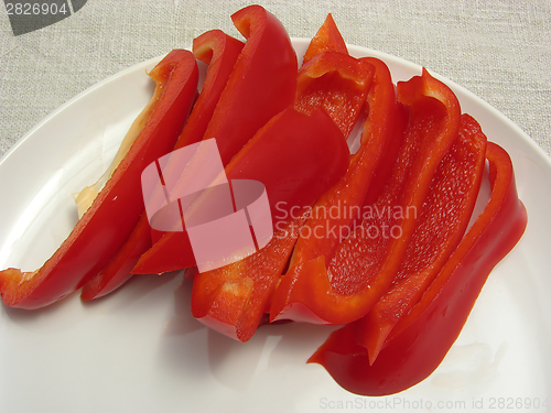 Image of Slitted red pepper on a white plate and placemat