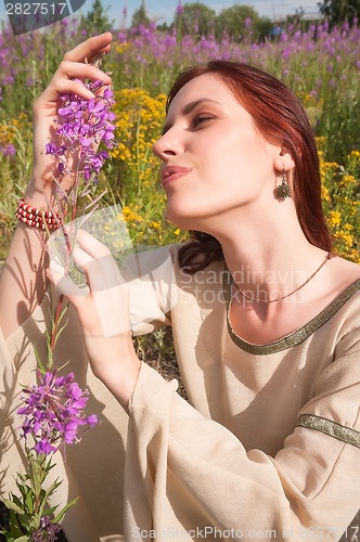 Image of Beautiful red-haired girl on meadow