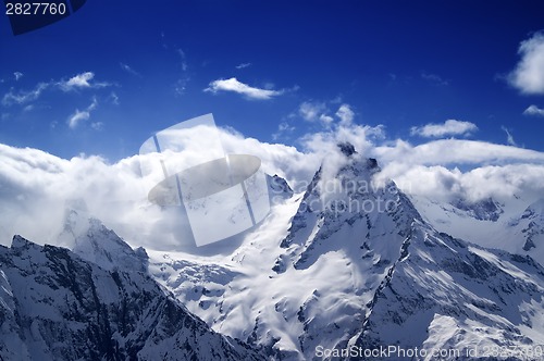 Image of Snowy mountains in sunlight clouds