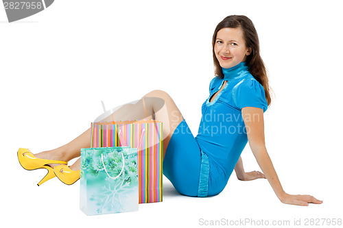 Image of woman with packages sitting on the floor