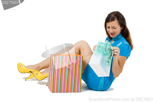 Image of woman with packages sitting on the floor