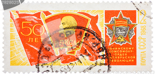 Image of Stamp printed in USSR, shows banner of komsomol with badge and O