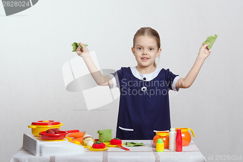 Image of Girl in the kitchen with cabbage leaves