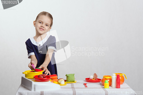 Image of Girl hostess prevents spoon in the pan