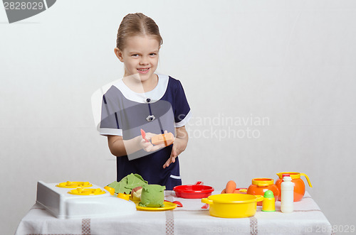 Image of Little girl preparing food in the pan