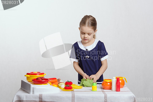 Image of Girl cut up head of cabbage