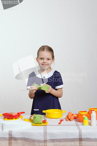 Image of Five-year hostess with cabbage leaves