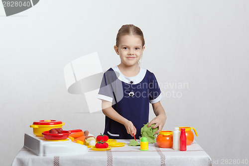 Image of Little girl preparing food in the kitchen