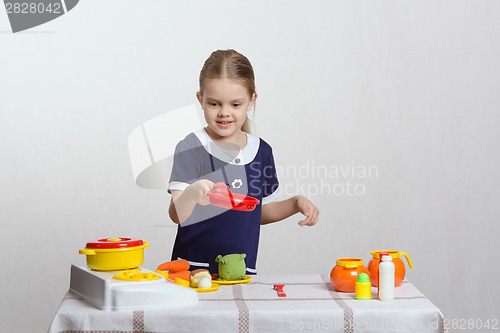 Image of Girl hostess keeps the pan with chicken