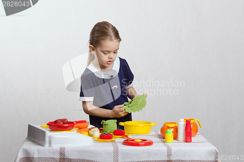 Image of Girl enthusiastically prepares soup