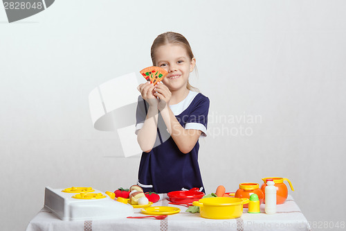 Image of Girl with a slice of pizza on children's kitchen