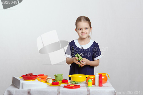 Image of Girl five years preparing soup