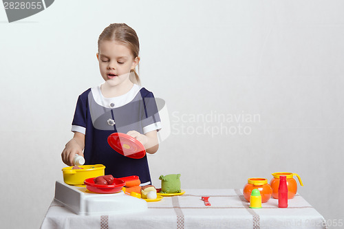 Image of Hostess girl pouring milk in a saucepan