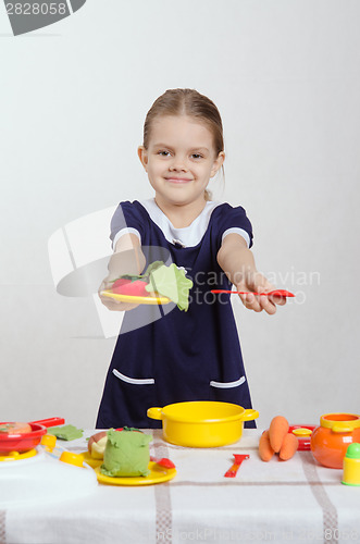 Image of Five-year hostess offers plate of food and a spoon