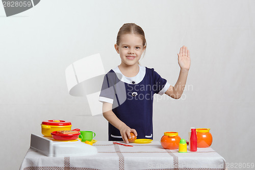 Image of Girl in the kitchen waving goodbye