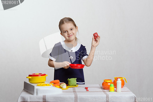 Image of Girl hostess puts chicken in the pan