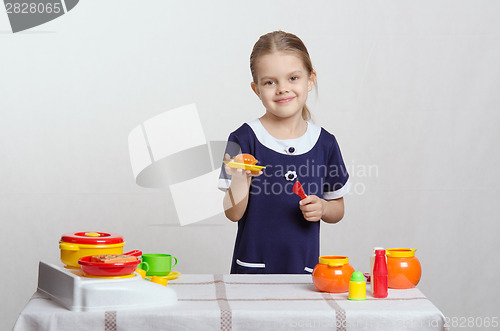 Image of Girl with a toy kitchen pie