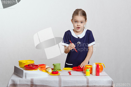 Image of Funny girl cuts a tomato