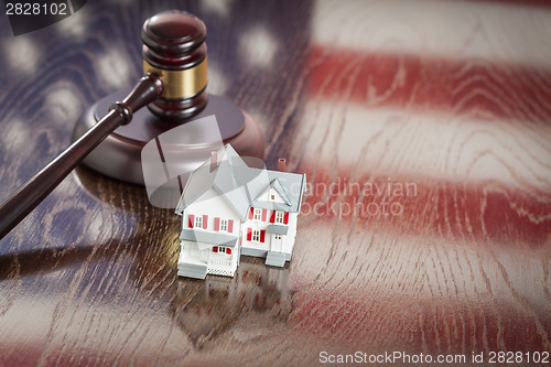 Image of Small House and Gavel on Table with American Flag Reflection