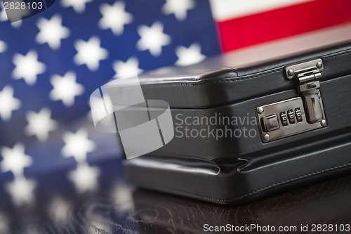 Image of Leather Briefcase Resting on Table with American Flag Behind