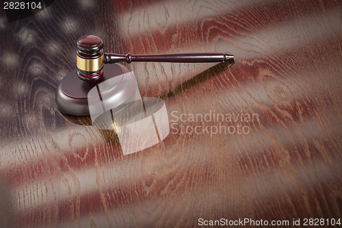 Image of Wooden Gavel Resting on Flag Reflecting Table