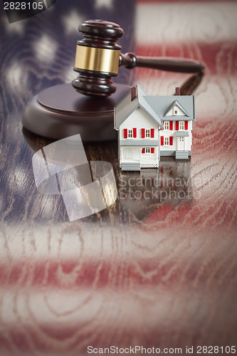 Image of Small House and Gavel on Table with American Flag Reflection