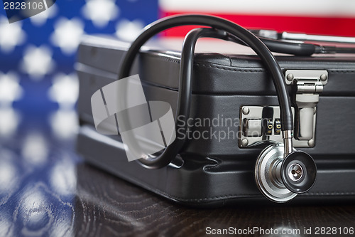 Image of Briefcase and Stethoscope Resting on Table with American Flag Be