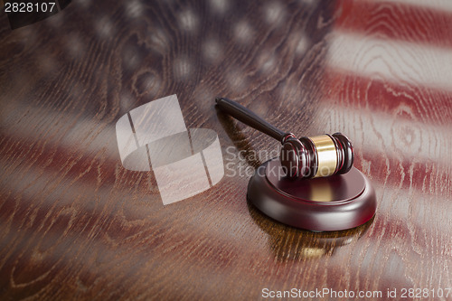 Image of Wooden Gavel Resting on Flag Reflecting Table