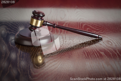 Image of Wooden Gavel Resting on Flag Reflecting Table