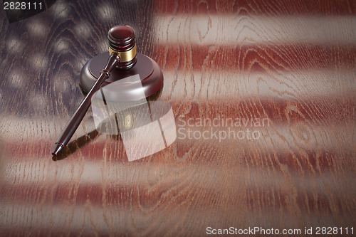 Image of Wooden Gavel Resting on Flag Reflecting Table