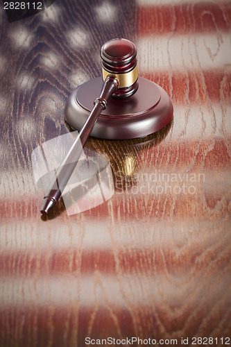 Image of Wooden Gavel Resting on Flag Reflecting Table