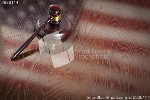 Image of Wooden Gavel Resting on Flag Reflecting Table