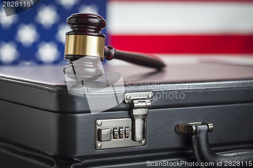 Image of Briefcase and Gavel Resting on Table with American Flag Behind