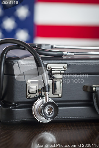 Image of Briefcase and Stethoscope Resting on Table with American Flag Be